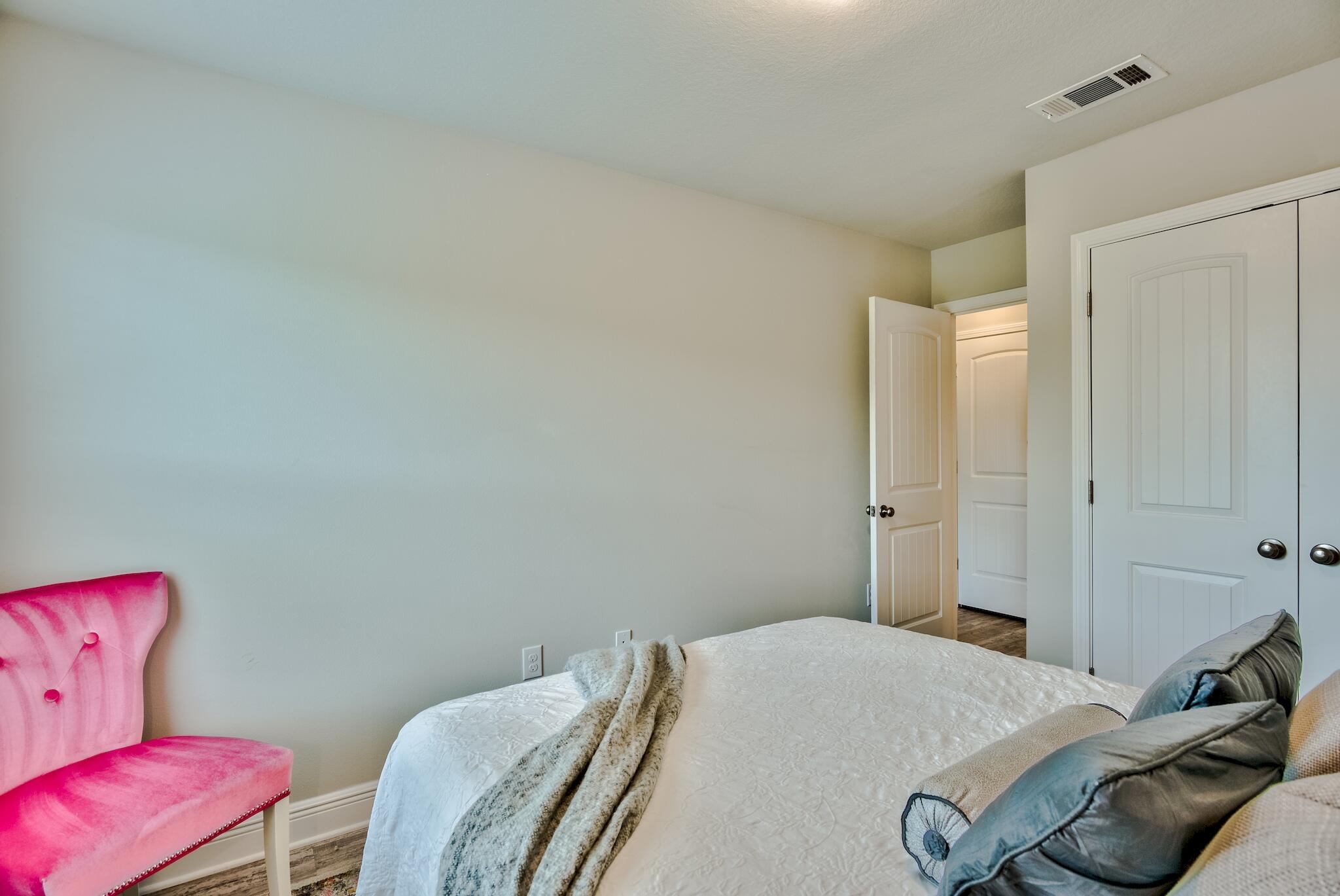 89 Crossing Lane, Unit C Santa Rosa Beach, FL 32459 - Photo 18 of 27 a bedroom with a bed and chair