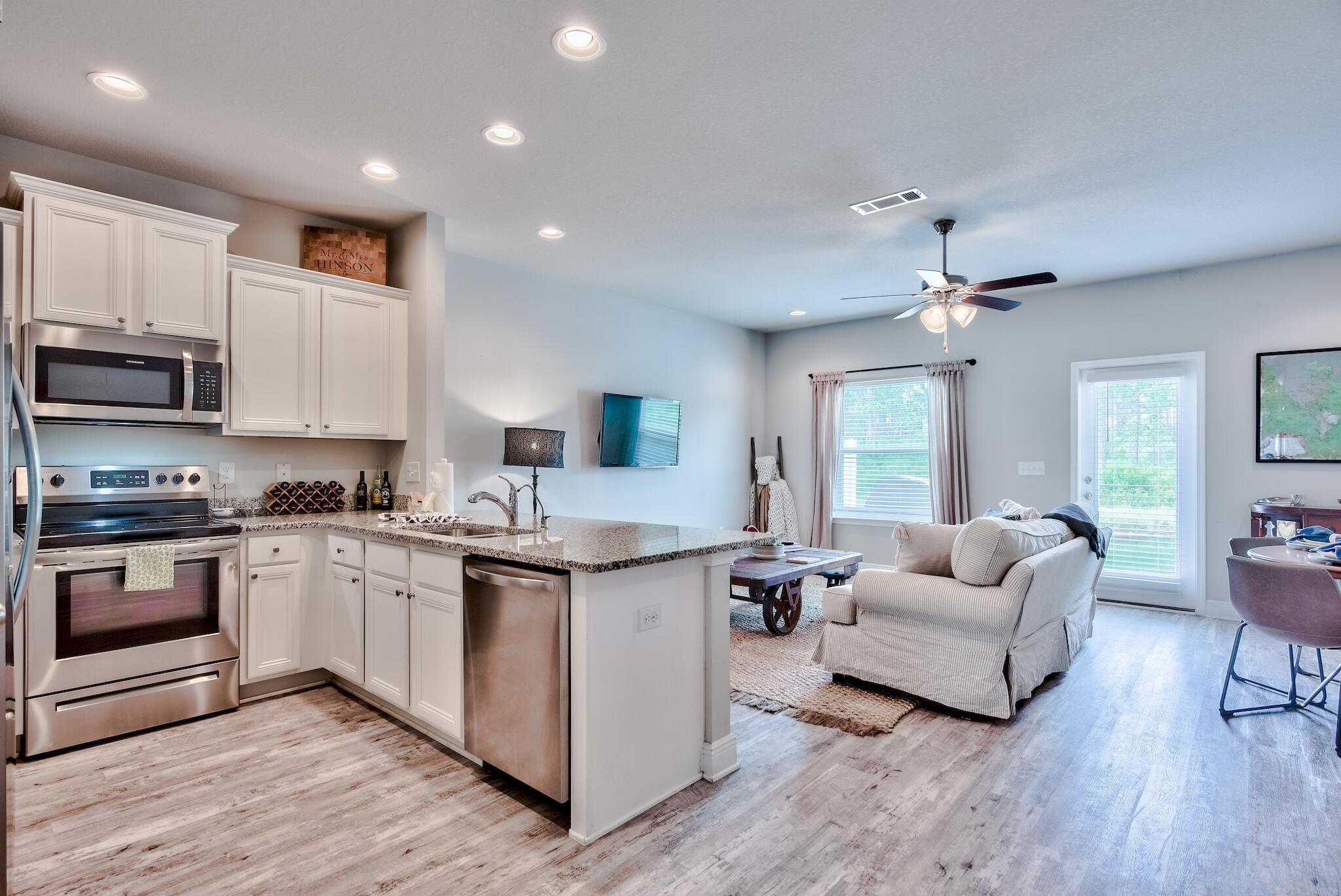 89 Crossing Lane, Unit C Santa Rosa Beach, FL 32459 - Photo 4 of 27 a kitchen with stainless steel appliances granite countertop wooden cabinets a sink dishwasher a stove and a refrigerator with wooden floor