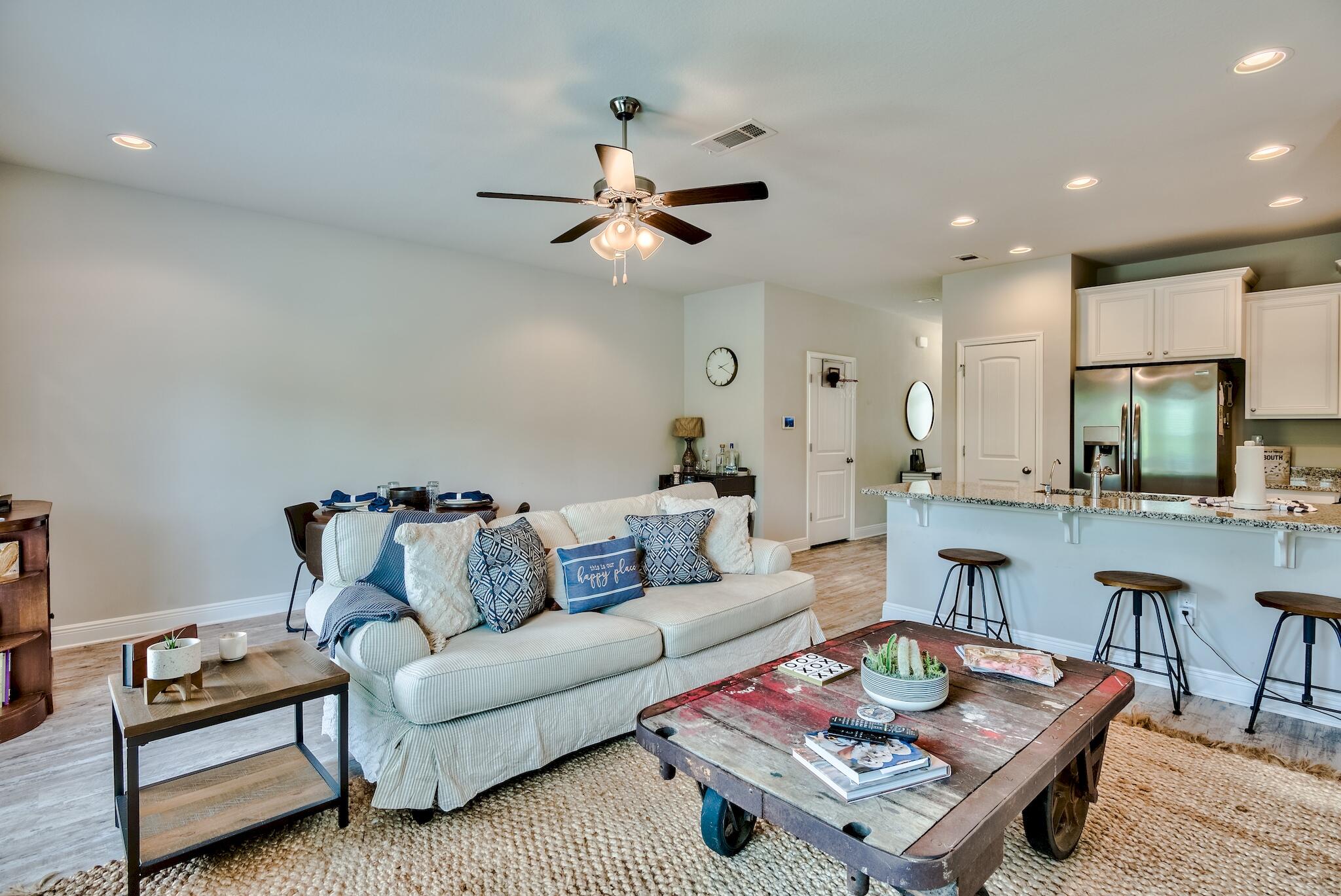 89 Crossing Lane, Unit C Santa Rosa Beach, FL 32459 - Photo 10 of 27 a living room with furniture a rug and a chandelier