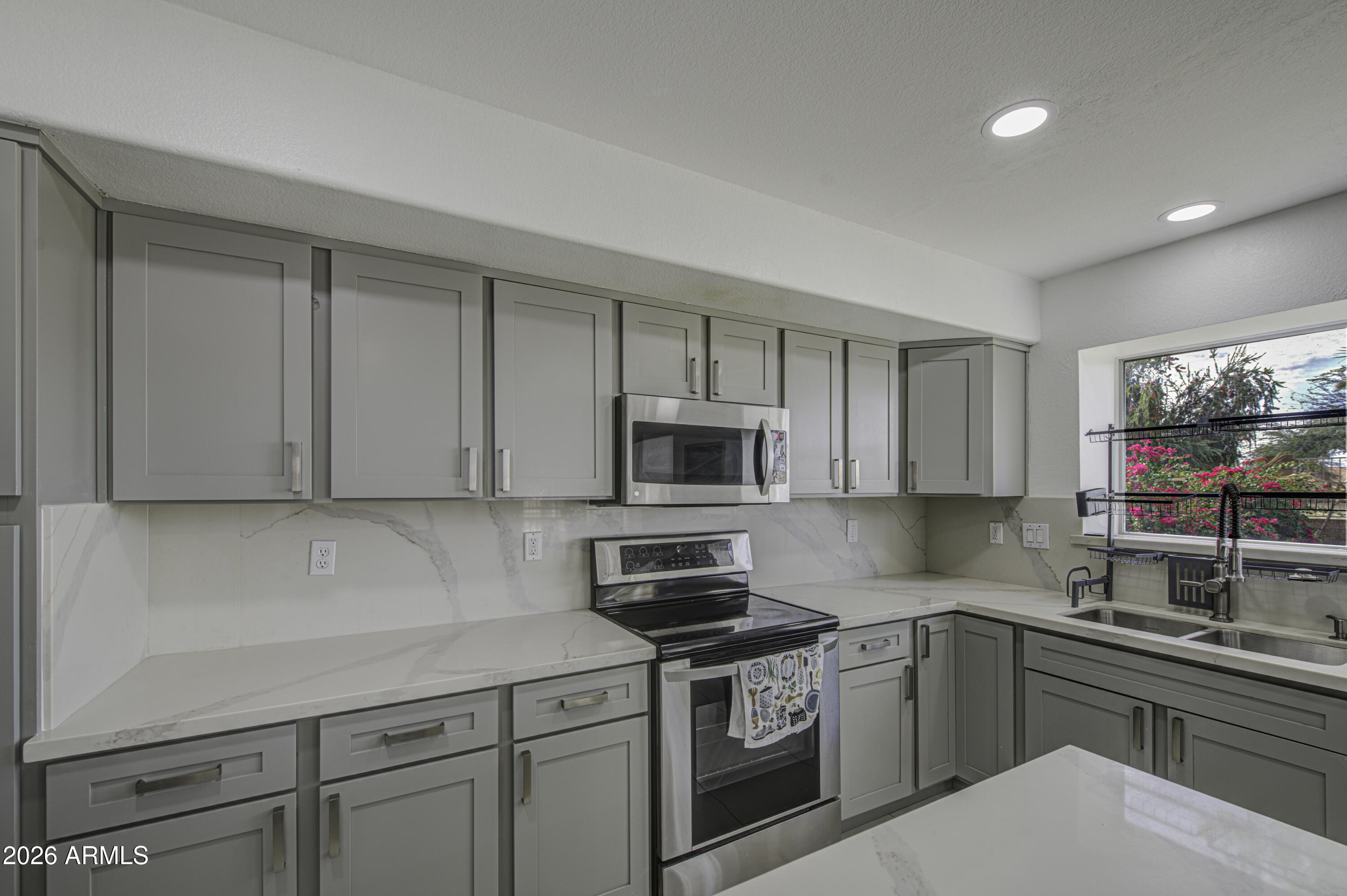 12403 West Monte Vista Road Avondale, AZ 85392 - Photo 19 of 63 a kitchen with granite countertop a sink cabinets and stainless steel appliances