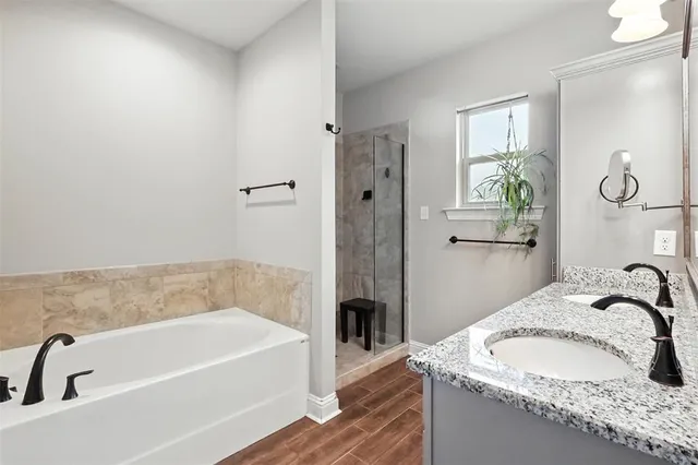 a bathroom with a granite countertop bathtub sink and mirror