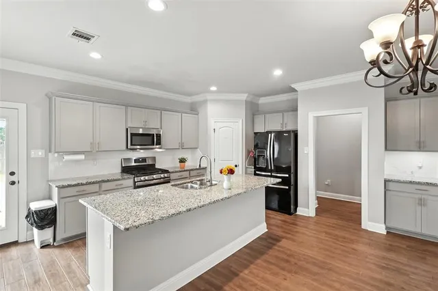 a large kitchen with a center island stainless steel appliances and cabinets