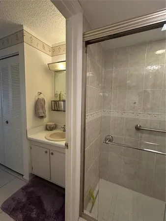 a bathroom with a shower sink and mirror