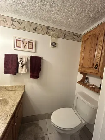 a bathroom with a granite countertop toilet sink and mirror