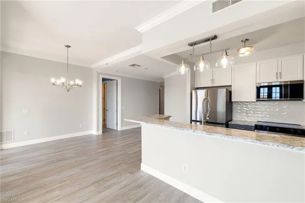 a view of a kitchen with a sink and refrigerator