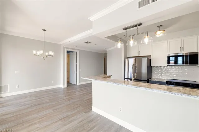 a view of a kitchen with a sink and refrigerator
