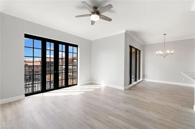 a view of an empty room with a window and a kitchen
