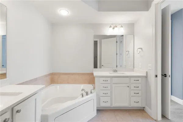 a bathroom with a tub sink and mirror