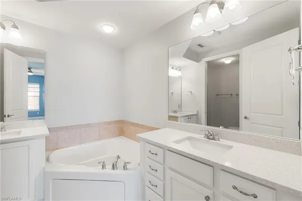 a bathroom with a sink a large mirror and a bathtub