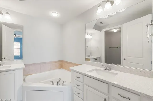 a bathroom with a sink a large mirror and a bathtub