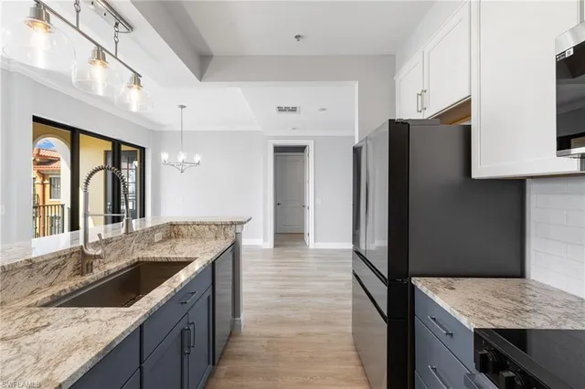a kitchen with granite countertop a sink stove and refrigerator
