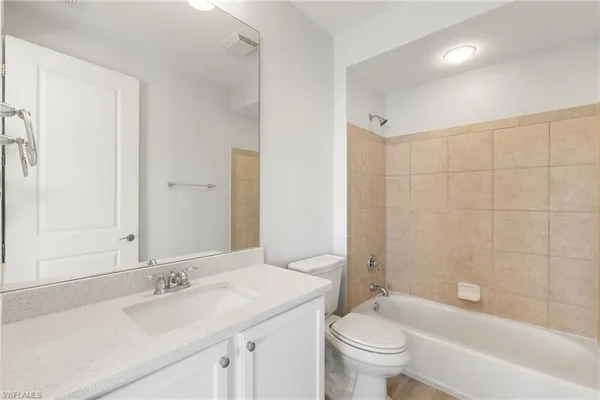 a bathroom with a granite countertop sink a toilet and a bathtub