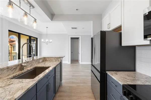 a kitchen with granite countertop a sink stove and refrigerator