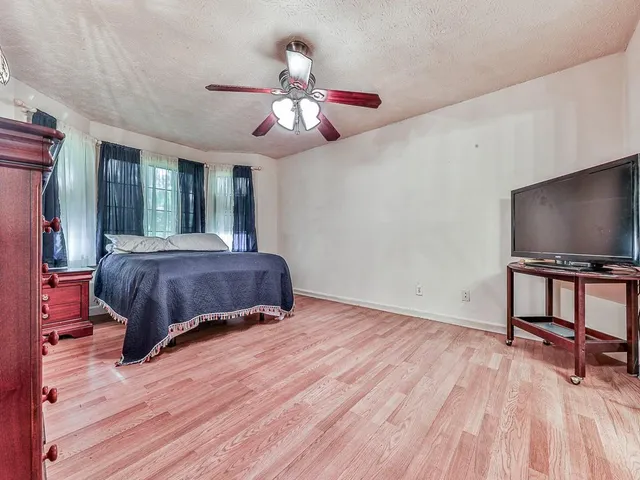 a living room with a bed furniture and a flat screen tv