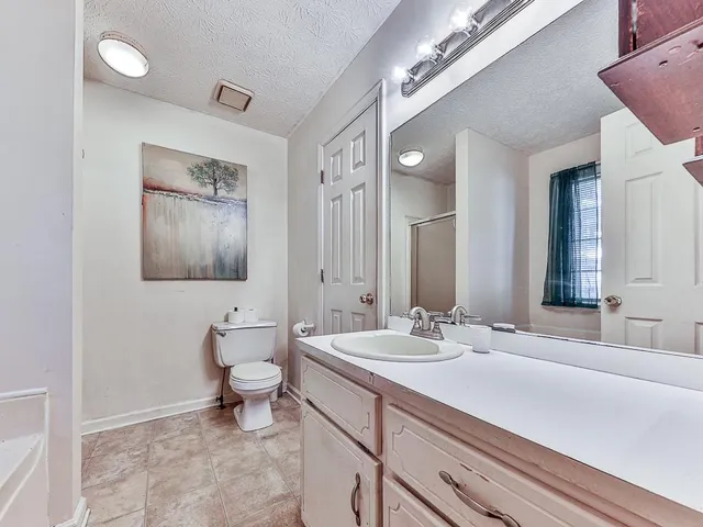 a bathroom with a double vanity sink mirror and toilet