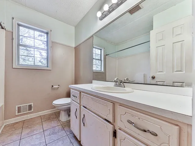 a bathroom with a sink a toilet and mirror