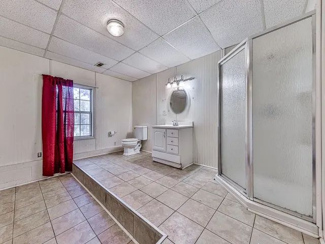 a living room with a large mirror and a glass door shower