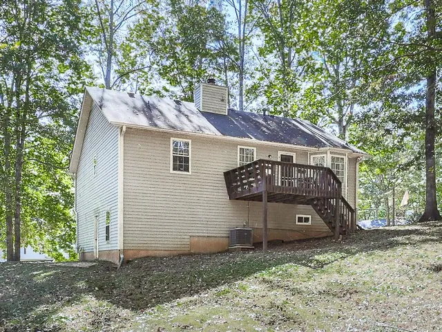 a view of a small house with a small yard and large tree