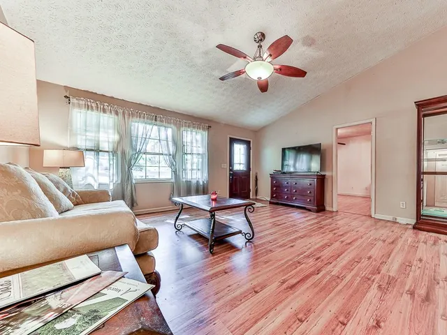 a living room with furniture and a wooden floor