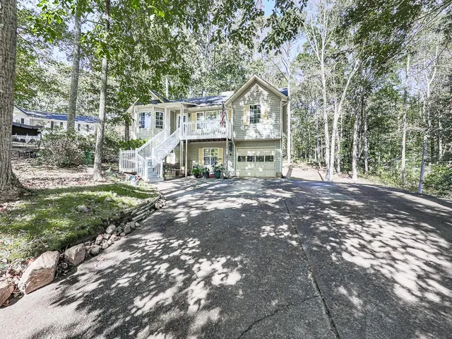 a front view of a house with large trees