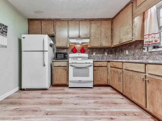 a kitchen with a refrigerator sink and cabinets