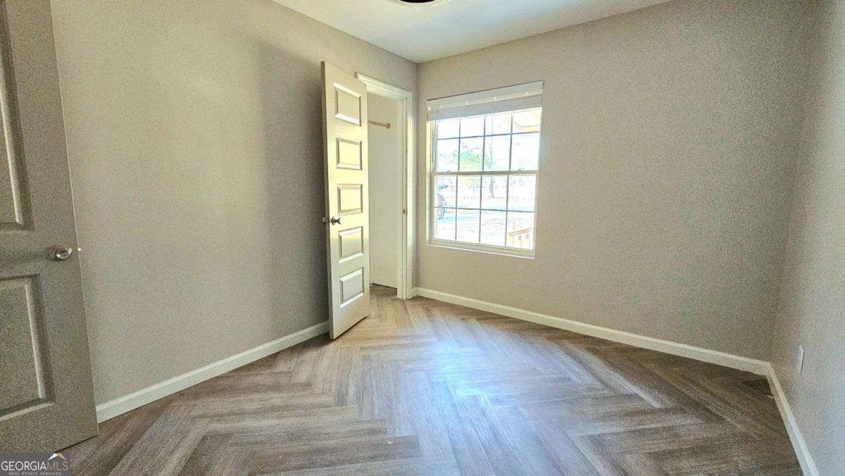 858 Augusta Road Valdosta, GA 31602 - Photo 13 of 28 an empty room with wooden floor and windows
