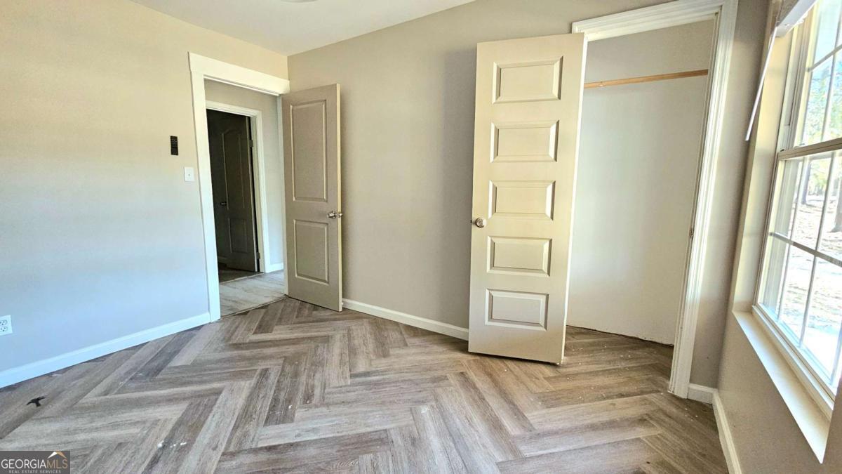 858 Augusta Road Valdosta, GA 31602 - Photo 14 of 28 a view of an empty room with wooden floor and a window