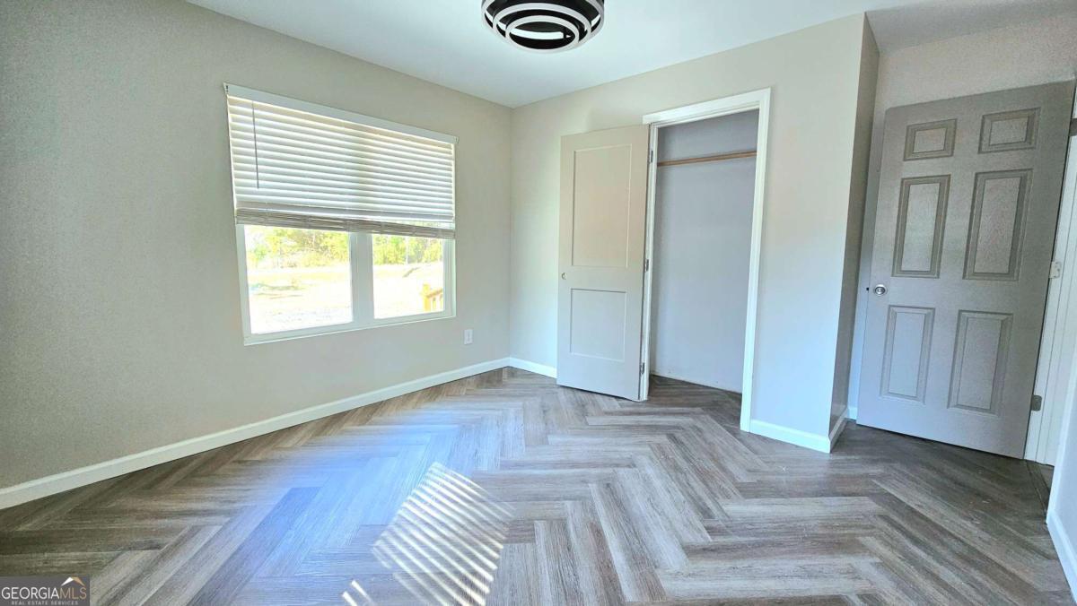858 Augusta Road Valdosta, GA 31602 - Photo 16 of 28 an empty room with wooden floor and windows
