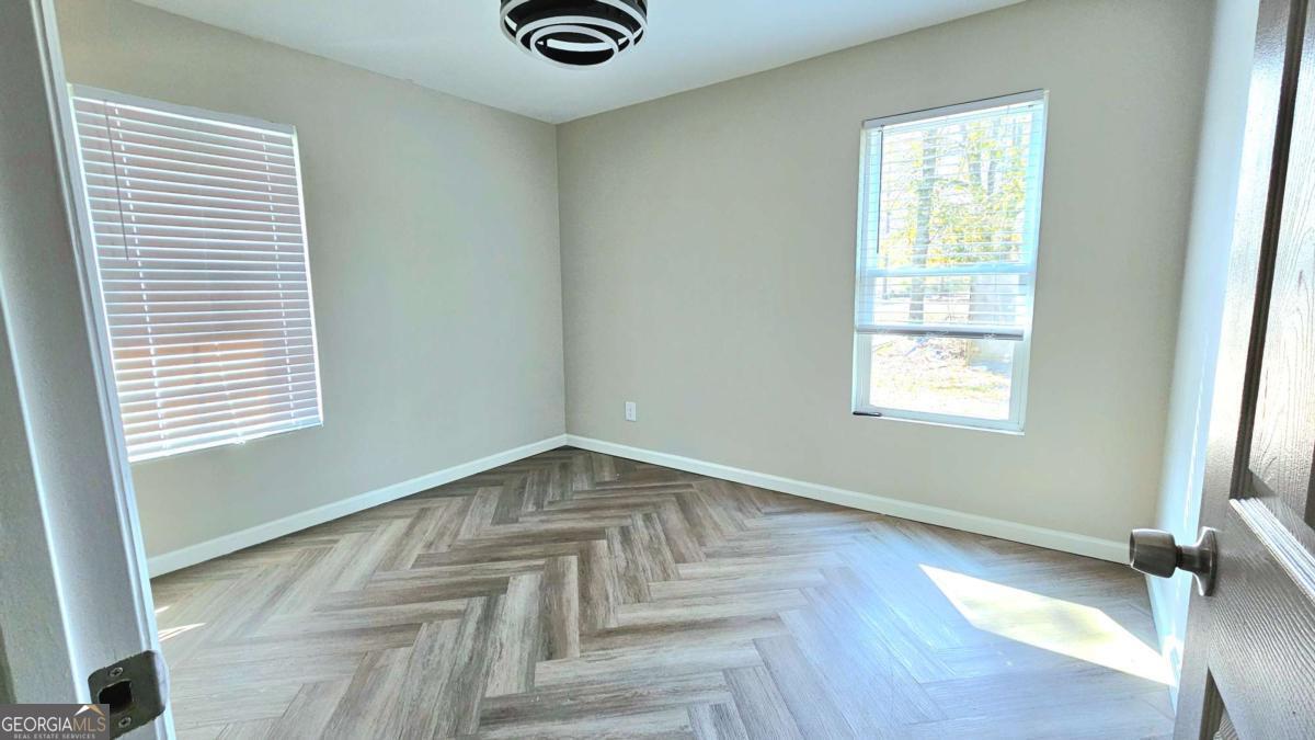 858 Augusta Road Valdosta, GA 31602 - Photo 18 of 28 a view of an empty room with wooden floor and a window