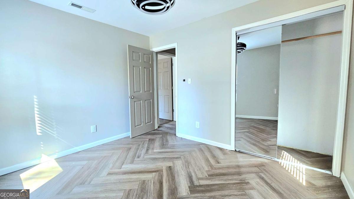 858 Augusta Road Valdosta, GA 31602 - Photo 20 of 28 a view of a hallway with wooden floor and a bathroom