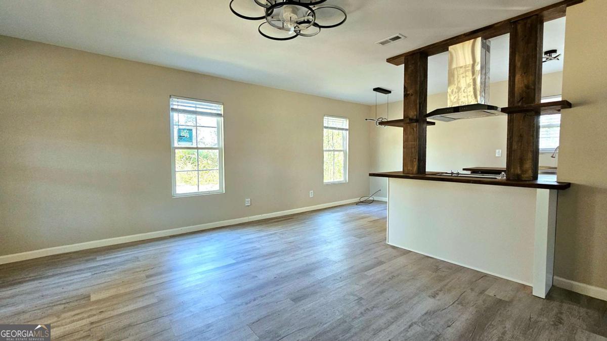 858 Augusta Road Valdosta, GA 31602 - Photo 6 of 28 a view of an empty room with wooden floor and a window