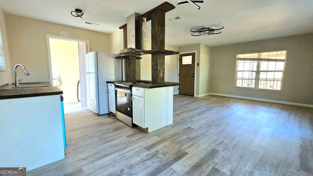 858 Augusta Road Valdosta, GA 31602 - Photo 8 of 28 a kitchen with stainless steel appliances granite countertop a refrigerator a stove and a wooden floors