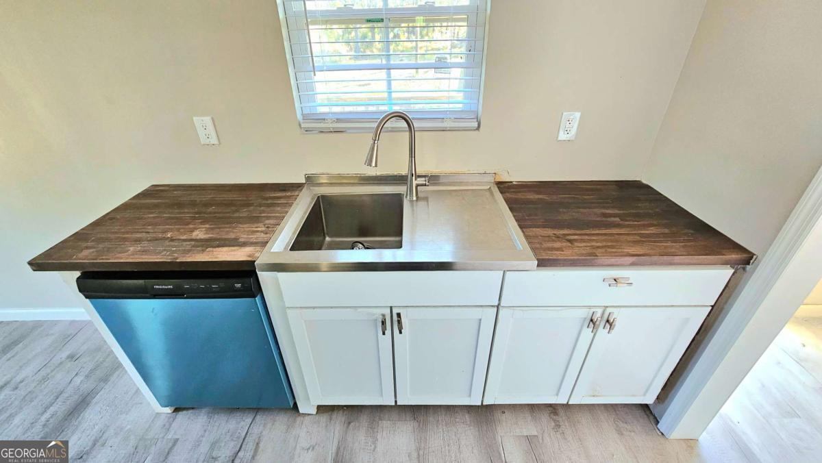 858 Augusta Road Valdosta, GA 31602 - Photo 10 of 28 a kitchen with wooden cabinets a sink and a window