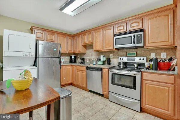 a kitchen with stainless steel appliances granite countertop a refrigerator sink stove microwave and cabinets