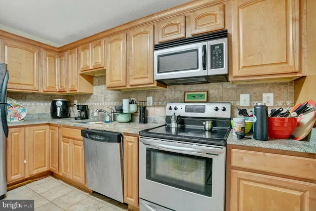 a kitchen with stainless steel appliances granite countertop cabinets and a stove top oven