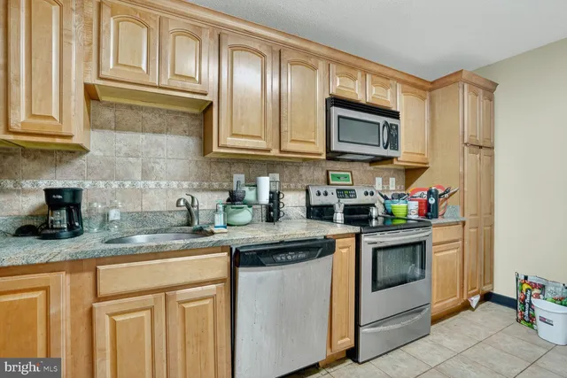 a kitchen with stainless steel appliances granite countertop a sink stove and microwave
