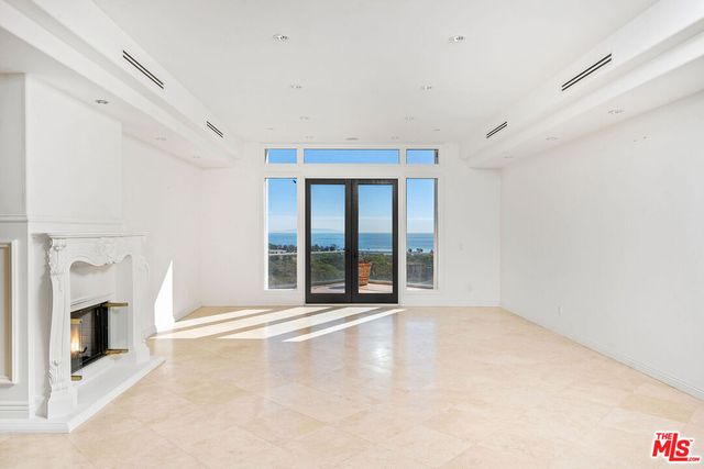 a view of an empty room with a fireplace and a window