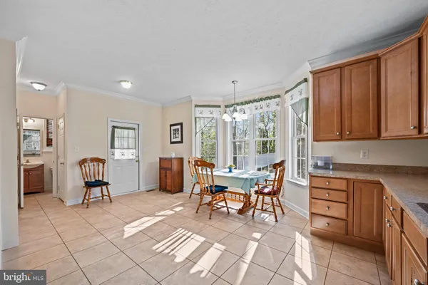 a dining hall with stainless steel appliances granite countertop a stove a sink a dining table and chairs with wooden floor