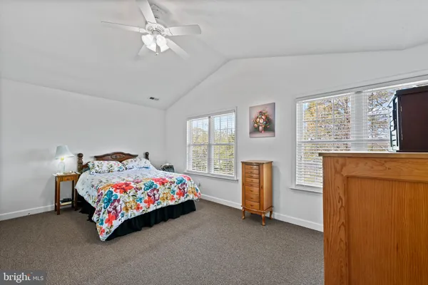 a room with a bed dresser and a window