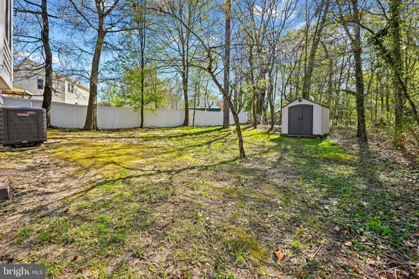 a backyard of a house with a tree and wooden fence