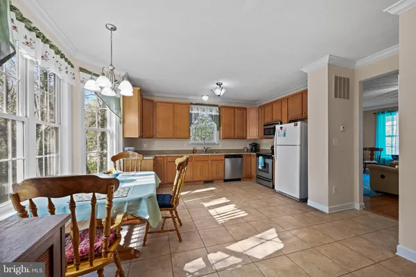 a room with stainless steel appliances kitchen island granite countertop furniture and a chandelier