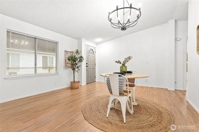 a view of a dining room with furniture a chandelier and wooden floor
