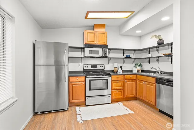 a kitchen with stainless steel appliances granite countertop a refrigerator and a stove top oven