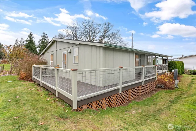a view of a house with wooden fence and a yard