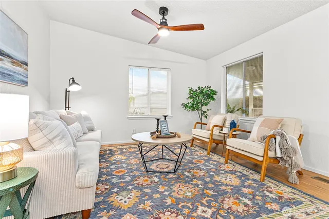 a living room with furniture two window and a table