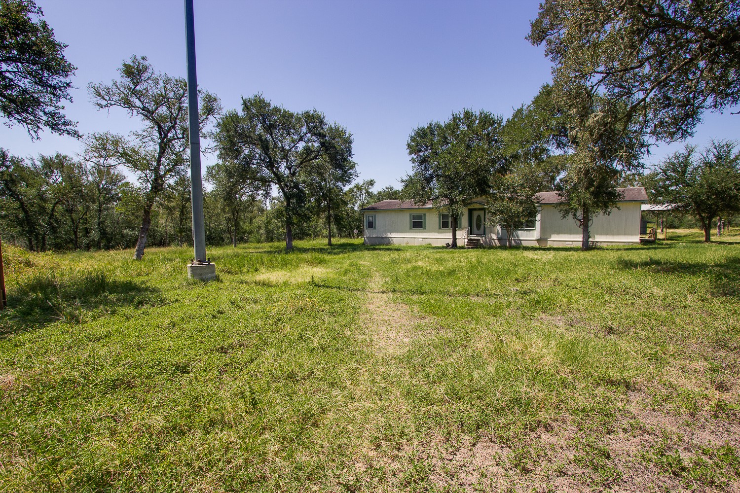 133 Mark Adams Road Del Valle, TX 78617 - Photo 20 of 20 Mature trees surround this home situated on a spacious grassy lot.