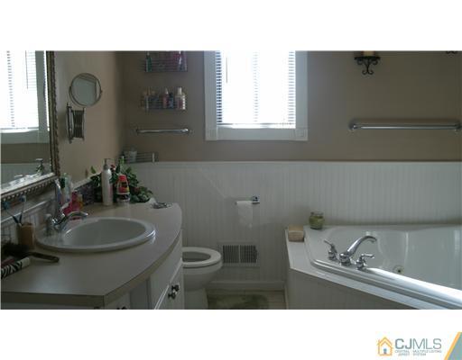 175 Penn Court Old Bridge, NJ 07747 - Photo 4 of 5 a bathroom with a sink vanity mirror and toilet