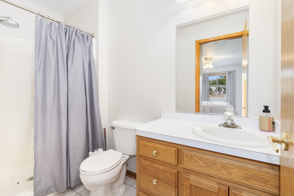 126 Twilight Lane New Lenox, IL 60451 - Photo 8 of 15 a bathroom with a sink a toilet and shower curtain