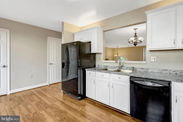a kitchen with granite countertop a sink stove and refrigerator