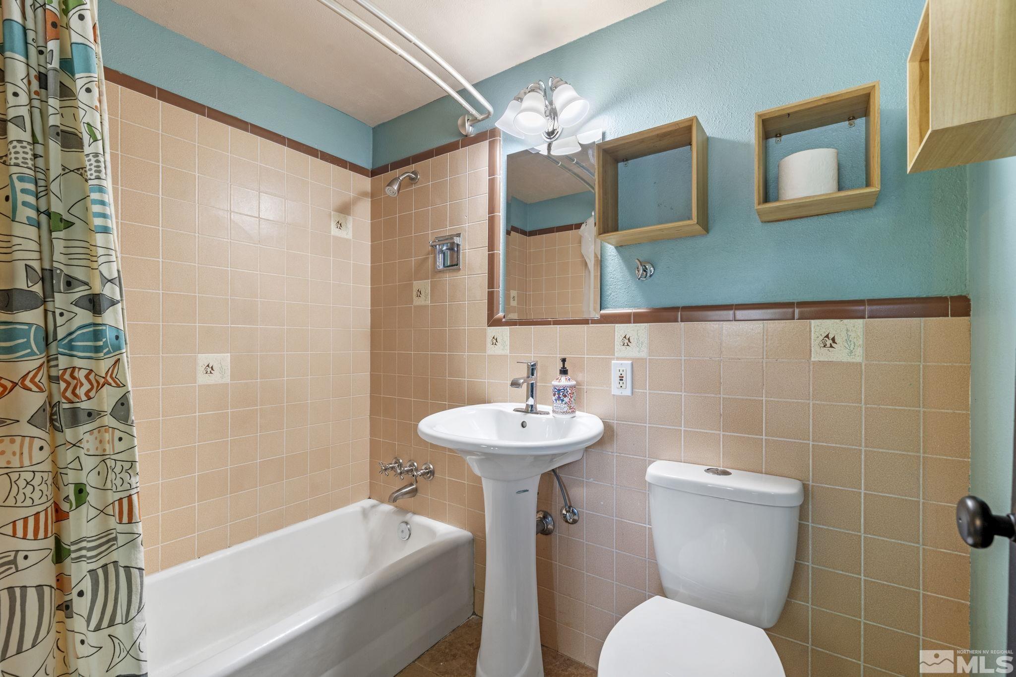 1005 Memory Lane Reno, NV 89509 - Photo 11 of 32 a bathroom with a sink mirror toilet and bathtub